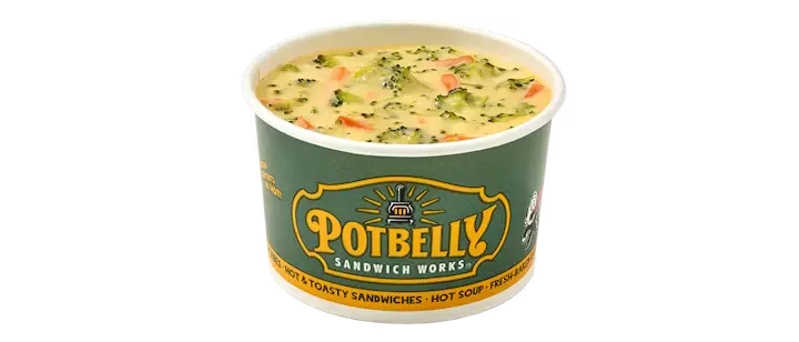 A cozy Potbelly Menu item, the Potbelly Broccoli Cheddar, featuring a creamy cheese soup loaded with tender broccoli and carrots, served in a branded green cup against a black background, priced at $5.49 with 233 calories.