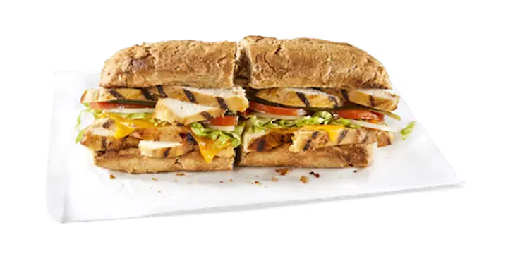 A flavorful Potbelly Menu item, the Grilled Chicken, featuring a toasted sub roll filled with all-natural grilled chicken, melted cheddar cheese, fresh lettuce, tomatoes, and pickles, cut into portions and served on white paper against a black background, priced at $10.89 with 573 calories.