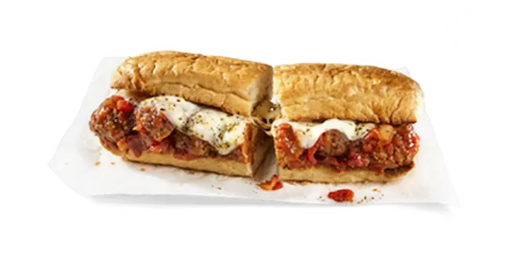 A hearty Potbelly Menu item, the Mama’s Meatball, featuring a toasted sub roll filled with homestyle beef and pork meatballs smothered in rich marinara sauce, melted provolone cheese, and sprinkled with Italian seasoning, cut into portions and served on white paper against a black background, priced at $11.29 with 727 calories.