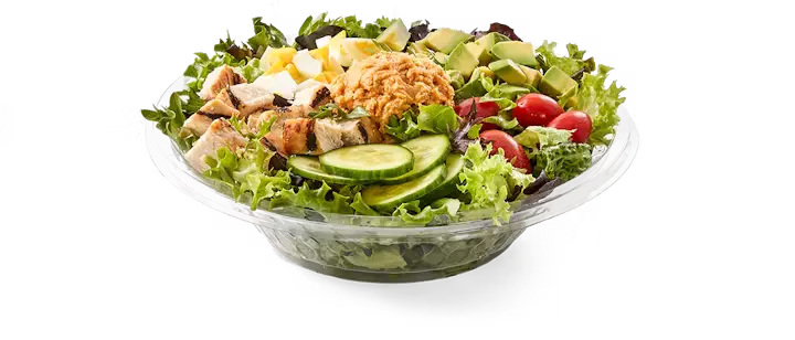 A nutritious Potbelly Menu item, the Potbelly Powerhouse Salad, featuring a colorful bowl of field greens topped with all-natural grilled chicken breast, fresh-sliced avocado, creamy hummus, hard-boiled egg, crisp cucumber, and juicy tomatoes, drizzled with light non-fat vinaigrette, served in a clear bowl against a black background, priced at $10.99 with 324 calories.